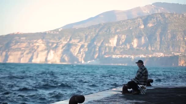 Gamla fiskare fångar en fisk i havet — Stockvideo