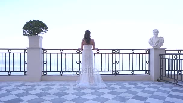 The bride standing on a balcony on the sea background — Stock Video