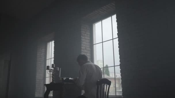 Hombre en camisa blanca escribiendo en máquina de escribir vista posterior — Vídeo de stock