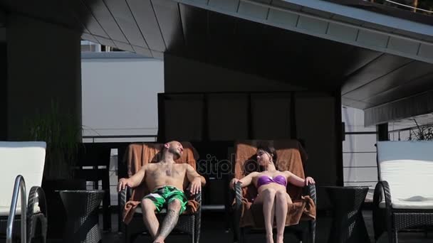 Couple relaxing on sun loungers — Stock Video