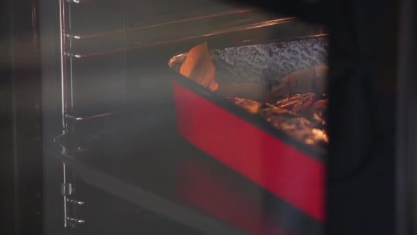 Повар достает рыбу из духовки — стоковое видео