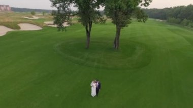 Gelin ve damat bir yeşil çim üstünde göster