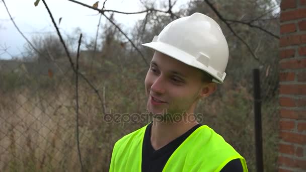 Construtor em um capacete sorri — Vídeo de Stock