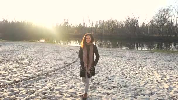 Het meisje wandelingen langs het zand in de buurt van de vijver — Stockvideo