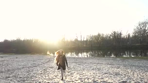 Дівчина гуляє піском біля ставка — стокове відео