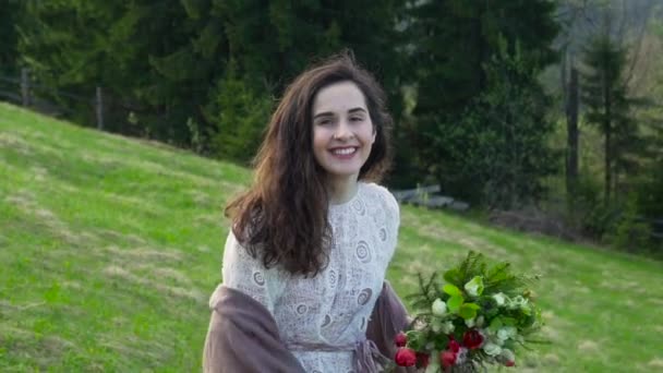 Девушка с цветами на зеленом холме — стоковое видео