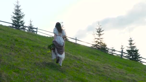 Mooi meisje loopt op de heuvel — Stockvideo
