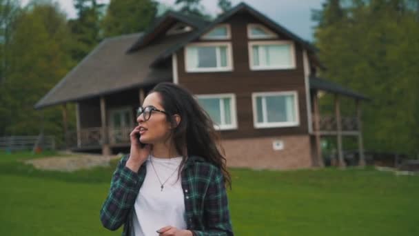 Tjejen pratar telefon i den gröna landsbygden — Stockvideo