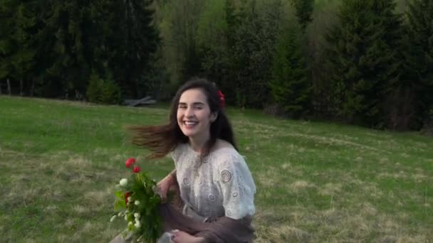 Chica con flores en el fondo del bosque — Vídeos de Stock