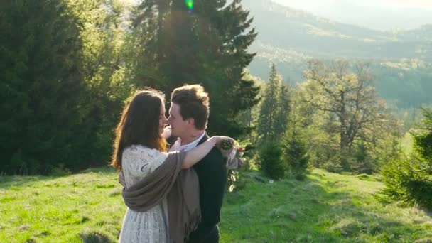 Pareja se está abrazando en las montañas y el fondo del bosque — Vídeos de Stock