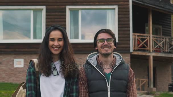 Ζευγάρι χαμογελώντας κοντά στο ξύλινο σπίτι — Αρχείο Βίντεο