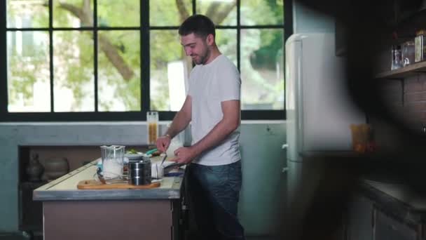 De man is een diner koken en glimlachen — Stockvideo