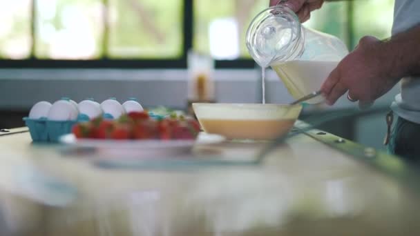 Ten přidává mléko do misky — Stock video