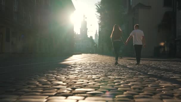 O casal está andando ao longo de pedras de pavimentação — Vídeo de Stock