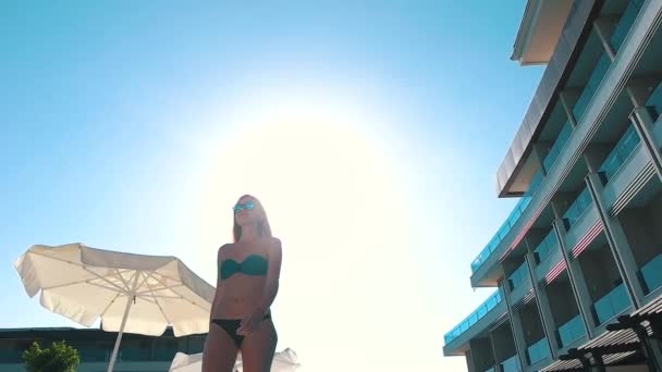 Ragazza in costume da bagno su sfondo blu cielo e hotel — Video Stock