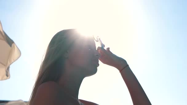 Menina coloca em seus óculos de sol — Vídeo de Stock