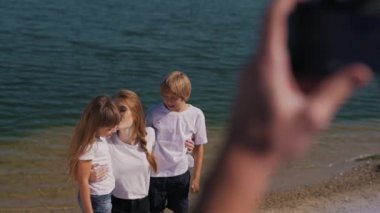 bir adam ailesini fotoğraf göl kenarında alır.