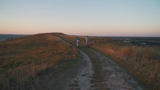 Ζευγάρι είναι ιππασίας ένα ποδήλατο στην εξοχή — Αρχείο Βίντεο