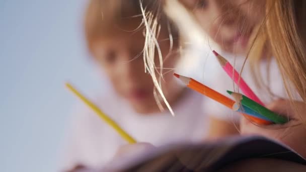 Niño y niña dibujan con lápices — Vídeo de stock