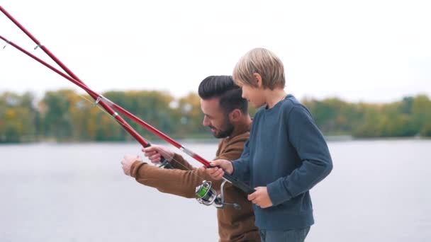 Father shows son how to fish — Stock Video