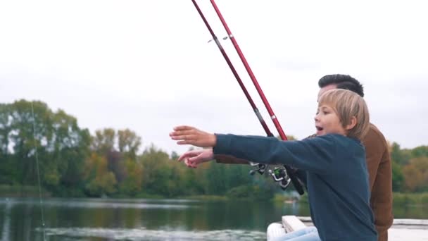 Vader en zoon vissen op het meer — Stockvideo