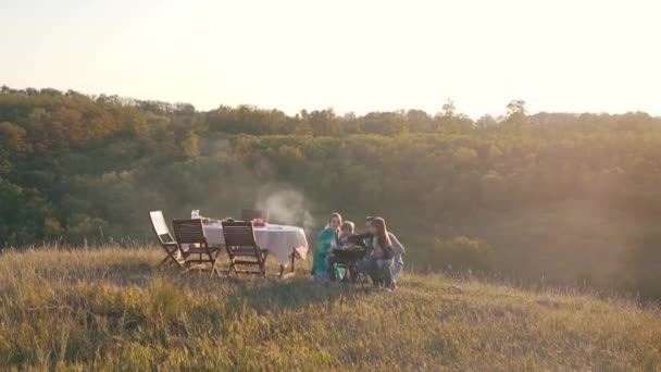 Familia feliz cocinar carne al aire libre — Vídeo de stock