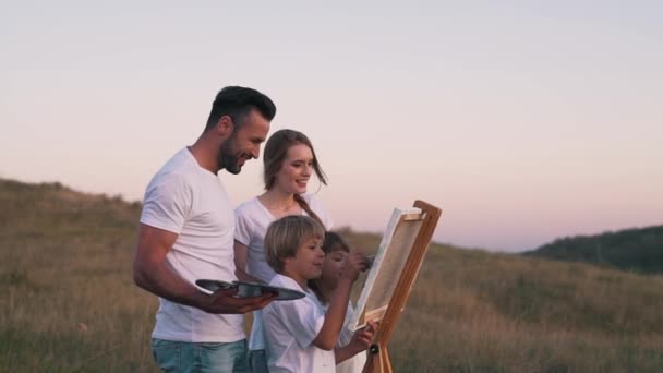 Szczęśliwa rodzina rysować obraz w polu — Wideo stockowe