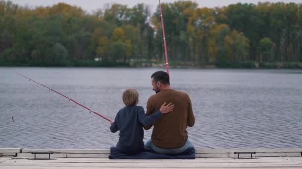 Папа поощряет своего сына к рыбалке — стоковое видео