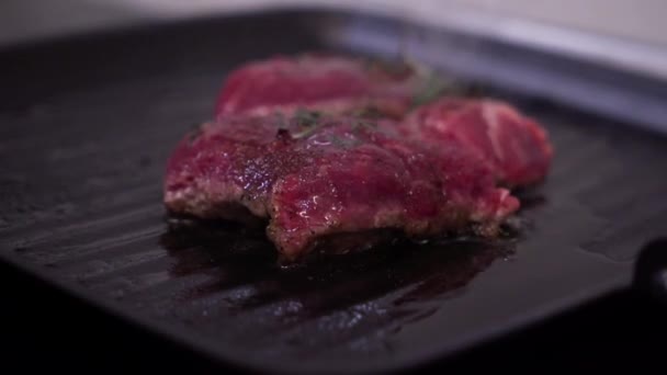 Повар жарит мясо на сковороде — стоковое видео