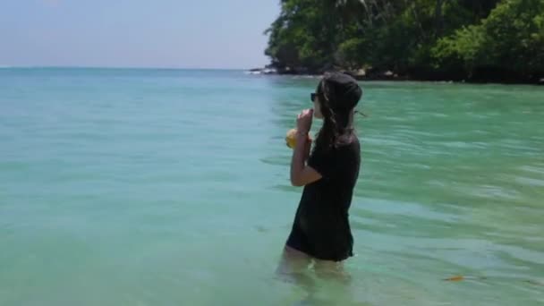 Дівчина з коктейлем в океані — стокове відео