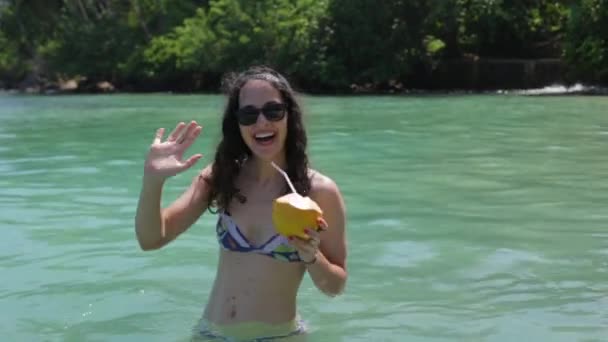Девушка пьет коктейль в океане — стоковое видео