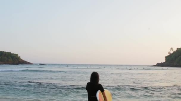 Menina com prancha de surf junto ao oceano — Vídeo de Stock