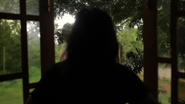 Flickan ser ut ur sin bungalow — Stockvideo