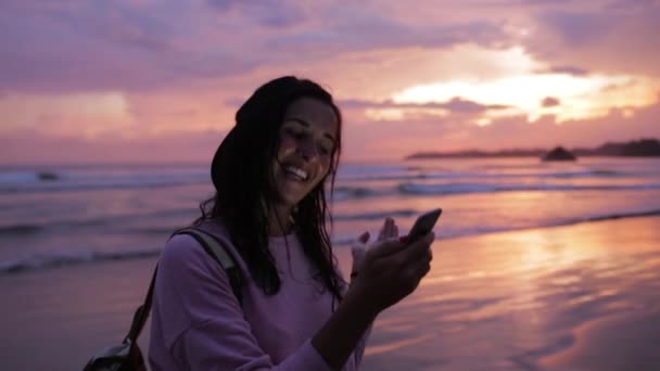 Chica charlando cerca del océano al atardecer — Vídeos de Stock