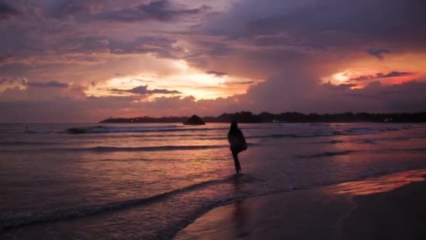 Menina andando ao pôr do sol perto do oceano — Vídeo de Stock