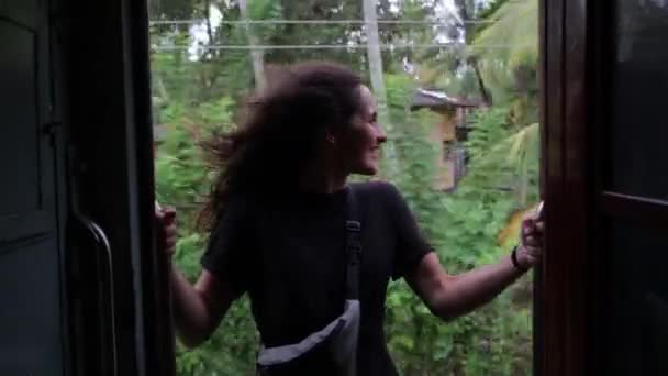 Дівчина подорожує поїздом у тропічному лісі — стокове відео
