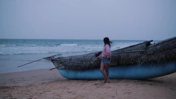 Chica cerca de un barco en el océano — Vídeo de stock