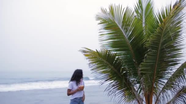 Chica bebe cóctel cerca de la palma — Vídeo de stock