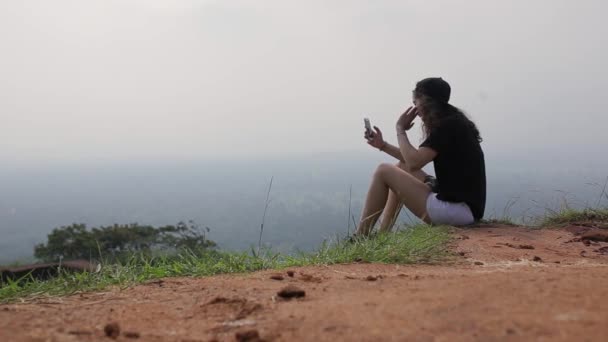 Турист разговаривает по телефону на вершине — стоковое видео