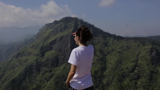 Ragazza guarda la valle da una cima — Video Stock