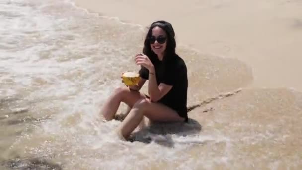Девушка пьет коктейль на пляже — стоковое видео