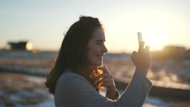 Meninas tira uma foto ao ar livre à luz do sol — Vídeo de Stock