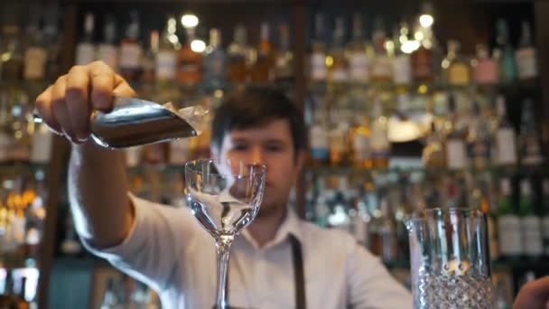 Barman giet ijs in een glas — Stockvideo