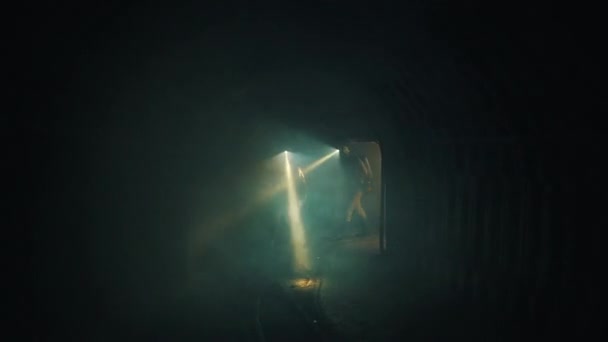 Спасатели с фонарями идут в туннель — стоковое видео