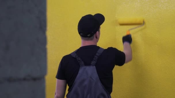 Trabajador pinta una pared en color brillante — Vídeo de stock