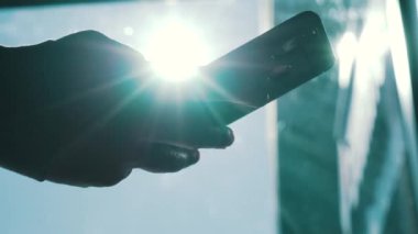Dışarıda akıllı telefon kullanan bir adam var.