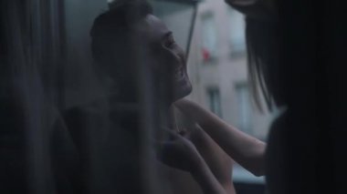 Birbirini seven çiftler pencerenin kenarında oturup eğleniyorlar.