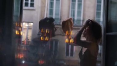Paris 'te bir apartmanın penceresinde iç çamaşırlı sevgili bir çift öpüşüyor.