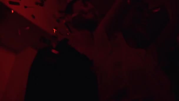 Couple s'amuser à une fête avec des lumières rouges et confettis — Video