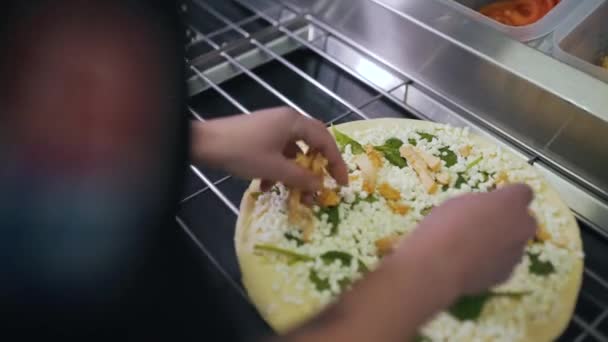 Kocken lägger fyllningen på pizzan — Stockvideo